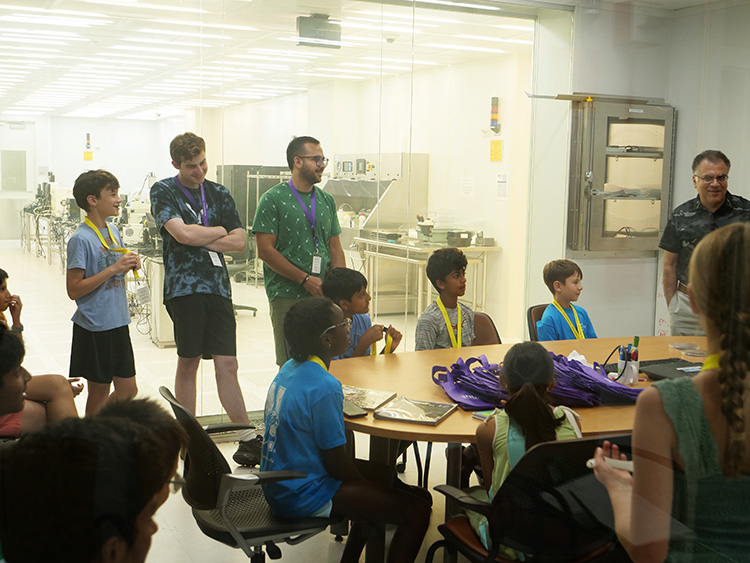 Middle School students listen as Nasir Basit, NUFAB Director talks about cleanrooms